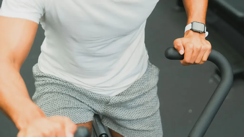 A compact upright exercise bike positioned in a small home workout corner