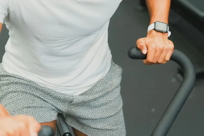 A compact upright exercise bike positioned in a small home workout corner