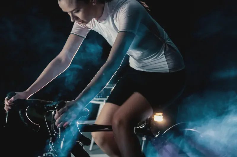 A compact upright exercise bike positioned in a small apartment living room near a wall