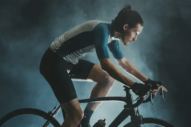 A beginner comparing an upright exercise bike, a recumbent exercise bike and a folding bike in a home workout space